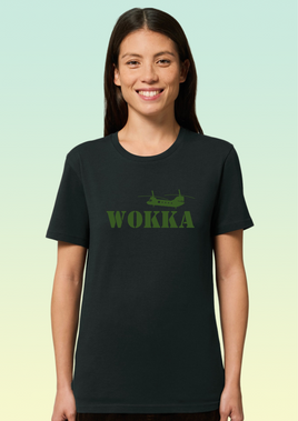 A woman wearing a black organic cotton women’s t-shirt with khaki print featuring a stylised Chinook helicopter above bold text reading WOKKA.