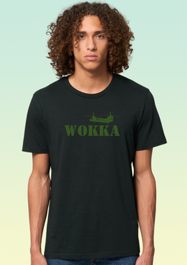 A man wearing a black heavyweight ring-spun cotton t-shirt with khaki print featuring a stylised Chinook helicopter above large text reading WOKKA.