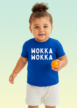 A little girl wearing a royal blue baby t-shirt with bold white WOKKA WOKKA text across the chest.
