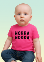 A baby wearing a pink cotton baby t-shirt with bold black WOKKA WOKKA text across the chest.