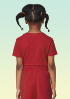 The back view of a girl wearing a red cotton t-shirt.